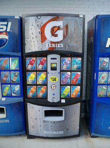 A person inspecting a used vending machine at a warehouse, representing the option of buying from distributors or auctions.